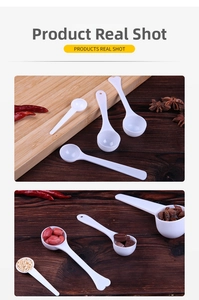 Macro detail of white plastic measuring spoons with heart-shaped handles in a kitchen setting