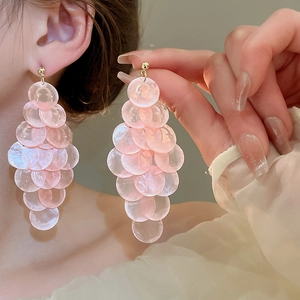 Detail of pink shell butterfly long tassel earrings on a model with elegant light