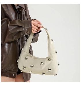 Detail of off-white hobo bag with large silver spherical studs and matte texture finish