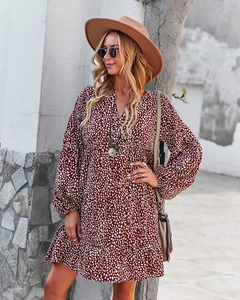 Detail of V-neck ruffled hem and leopard pattern on long sleeve wrap dress