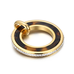 Gros plan d'un pendentif rond plaqué or avec acétate écaille de tortue et bordure zircon