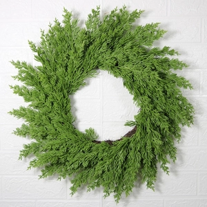 Artificial Christmas wreath with green pine needles on a brown natural rattan vine base