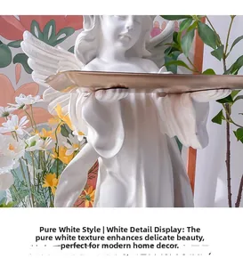Close-up of white resin angel statue holding a gold metal tray for home decoration