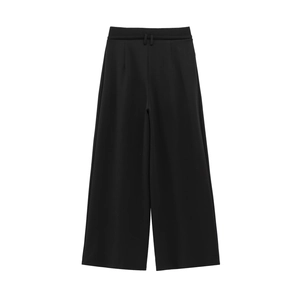 Detailed close-up of high-waisted black wide-leg trousers showing woven fabric texture