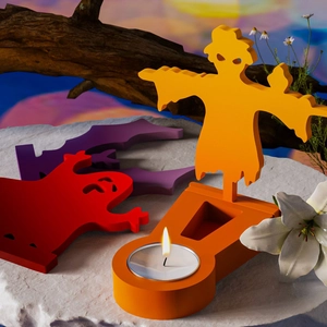 Halloween candle holder set with orange scarecrow and bat ornaments on a stone surface