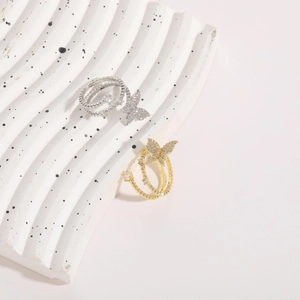 Detailed macro of crystal butterfly rings in 14k gold and silver with beaded texture
