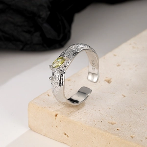 Detailed macro view of S925 silver ring with lava texture and olive green gemstone