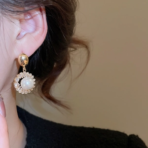 Close-up of a 18k gold plated pearl earring with pavé zircon detail on a female model