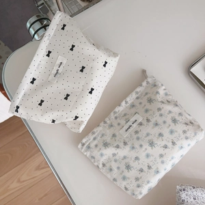 Minimalist cotton floral and polka dot makeup bags with zipper on white surface