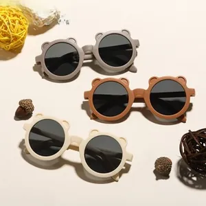 Detail of cute bear-ear sunglasses for kids in matte grey, brown, and cream colors
