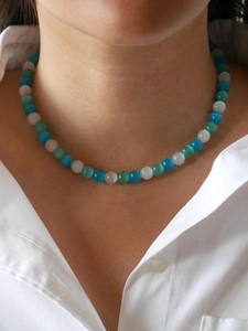 Close-up of glacier blue cat eye beaded necklace with heart pendant on model's neck