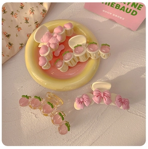 Detail of pink peach hair claw clips and bow hair accessories on a decorative tray