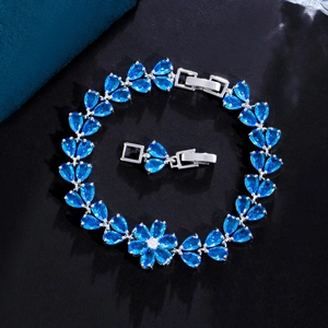 Detailed close-up of blue zircon flower bracelet with tear-drop cut crystals on black texture