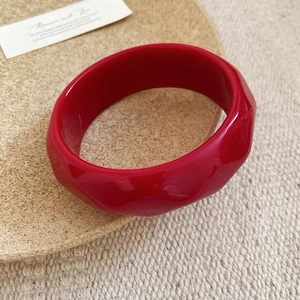 Fashionable bright red acrylic bangle featuring a geometric wavy textured resin surface