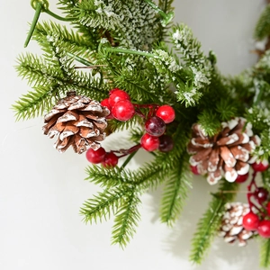 Weihnachtskranz mit verschneiten Tannennadeln, Zapfen und roten Beeren auf weißem Grund