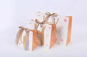 Three assorted sizes of cartoon bear gift bags with elegant gold handles and silk ribbons