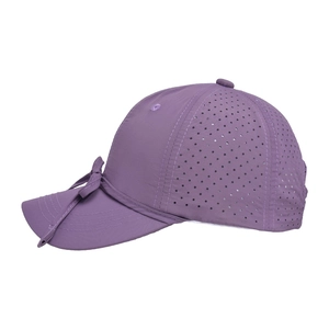 Close-up of laser-cut ventilation holes and purple bow on a quick-dry baseball cap