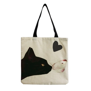 Detail of a beige canvas tote bag with a black cat watching a butterfly and heart print