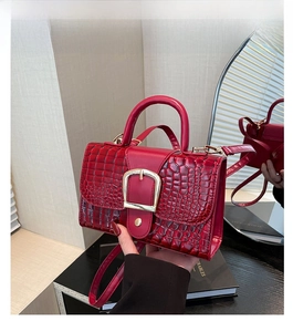 Détails avant et arrière du sac à main rouge motif crocodile avec boucle fer à cheval dorée
