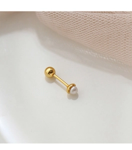 Detail of gold pearl screw back ear stud on an elegant creamy white mirror background