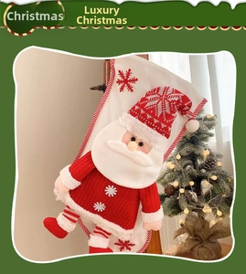 Detail of 3D Santa Claus figure on a white and red Christmas stocking gift bag