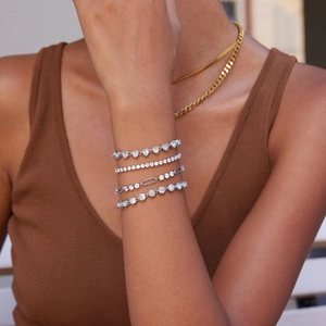 Close-up of layered silver bracelets with AAA zircon heart and tennis chain on model