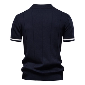 Dettaglio polo in maglia blu navy con pieghe verticali e bordi delle maniche a righe bianche