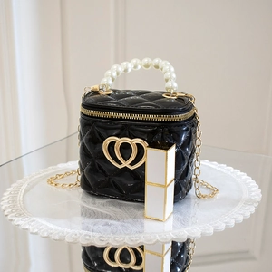 Glossy black quilted mini bucket bag with pearl handle and gold heart detail