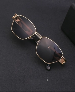 Detail of gold steampunk sunglasses with intricate cloud patterns engraved on the temple hinges