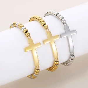 Bracelets à perles avec croix vintage en or et argent sur un support d'exposition blanc