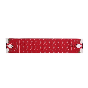 Red Christmas table runner with white snowflakes and gnome motifs for festive dining decor