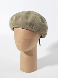 Detailed macro view of the khaki mesh knit texture on a breathable summer beret hat