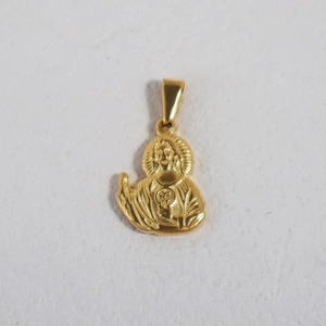 Macro view of gold plated stainless steel religious pendant with intricate relief detail
