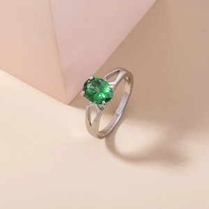Elegant silver ring featuring an oval green gemstone with micro-set zircon accents