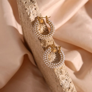Macro detail of 18K gold plated hoop earrings with rows of elegant white pearls