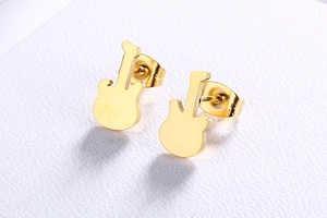 Detailed view of gold-toned guitar stud earrings on a clean white textured surface