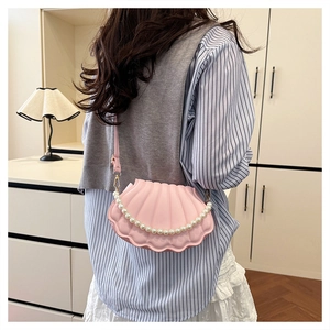 Pink shell-shaped crossbody bag with decorative pearl chain and smooth texture detail