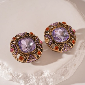 Makroaufnahme von Vintage-Ohrringen mit lila Edelsteinen und Bronze-Filigran-Details