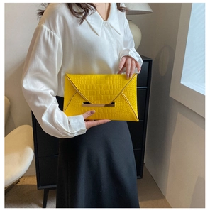 Détail de la texture crocodile jaune et de la bordure dorée de cette pochette enveloppe