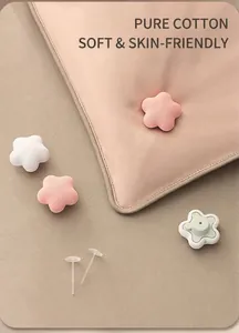 Detail view of cotton flower duvet clips installed on pink bedding for secure sheets