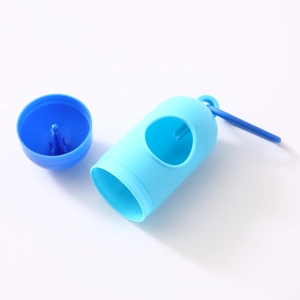 Detail of blue capsule-shaped pet waste bag dispenser with carabiner on white background