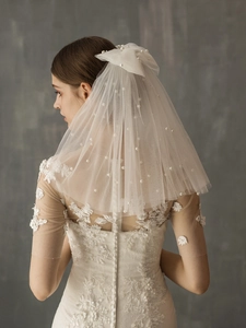 Close-up of elegant double-layered bridal veil with white pearls and a delicate bow detail