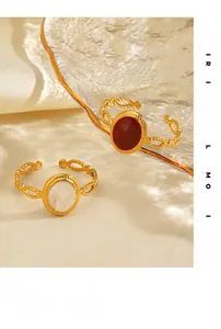 Close-up of vintage gold twist rings with red gemstone and white pearl inlay