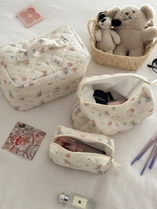 Detailed macro view of three quilted toiletry bags with cute blue rabbit and heart prints