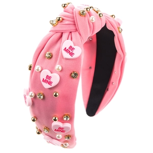 Détail d'un serre-tête noué rose avec perles en forme de cœur et texte Be Mine