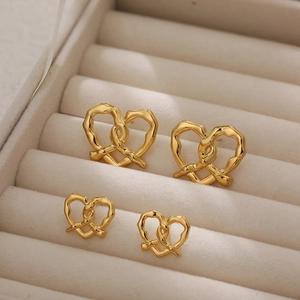 Macro shot of 18K gold knot heart earrings in a velvet case with different sizes