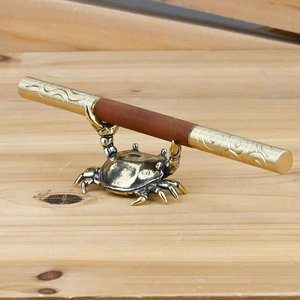 Vintage brass crab pen holder and desk ornament with detailed claws holding a metal rod