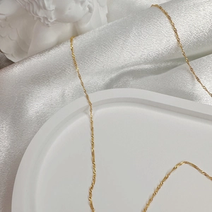 Elegant gold plated S925 sterling silver water wave chain necklace on white silk fabric