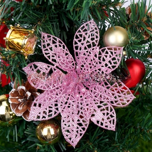 Pink glitter hollow Christmas flower ornament on a decorated festive tree branch