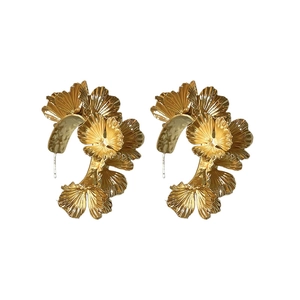 Boucles d'oreilles dorées en forme de C avec feuilles de ginkgo et texture métallique